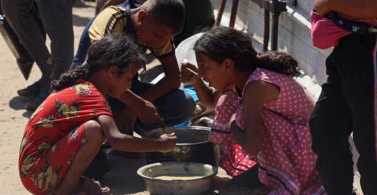 En un comedor social de Jan Yunis, en el sur de la Franja de Gaza, se reparten raciones de comida caliente entre los niños palestinos. Mientras esperan su turno, algunos comen arroz cocido.
