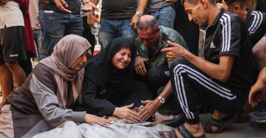 Los palestinos lloran junto al cadáver de un familiar asesinado en los ataques israelíes contra la ciudad de Gaza al amanecer, en el hospital Al-Shifa. 