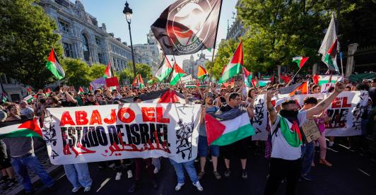 Manifestantes pro palestinos enarbolan banderas y pancartas palestinas tras invadir la calle y obligar a los organizadores de la carrera a suspender la 21.ª y última etapa de la Vuelta a España 2025, una carrera de 101 km entre Alalpardo y Madrid, en Madrid.