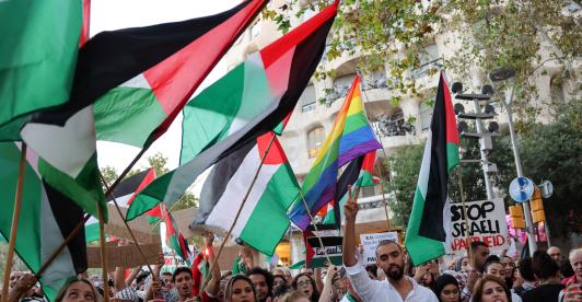Manifestantes hacen gestos y ondean banderas palestinas durante una concentración convocada por la «Comunitat Palestina de Catalunya» (Comunidad Palestina de Cataluña) en solidaridad con los palestinos, frente al edificio «Casa Milà» del arquitecto español Antonio Gaudí, conocido popularmente como «La Pedrera», en Barcelona.