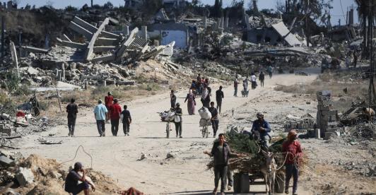 Vertriebene Palästinenser gehen an zerstörten Gebäuden vorbei, als sie in ihre Häuser im Gebiet al-Zahra nördlich des Flüchtlingslagers Nuseirat im zentralen Gazastreifen zurückkehren.