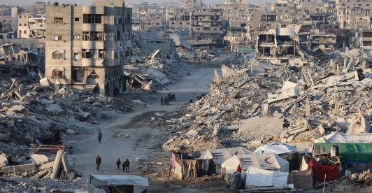 Palestinos caminan entre los escombros de edificios destruidos en el barrio de Sheikh Radwan, en la ciudad de Gaza.