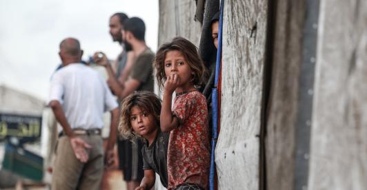 Niñas palestinas desplazadas junto a la entrada de una tienda utilizada como refugio temporal en Deir el-Balah, en la Franja de Gaza central.