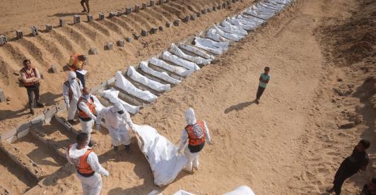 Trabajadores sanitarios y civiles realizan un entierro masivo de palestinos en un cementerio de Jan Yunis, en el sur de la Franja de Gaza.
