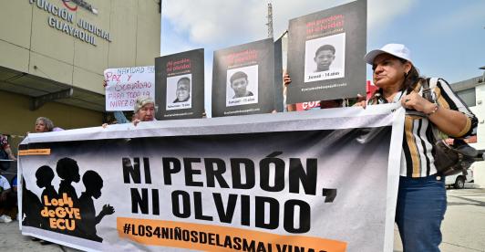 Familiares y miembros de organizaciones de derechos humanos sostienen fotografías y una pancarta con el lema «Ni perdón ni olvido» frente a un tribunal de Guayaquil, Ecuador, tras la condena de los 11 militares por desaparición forzada. 