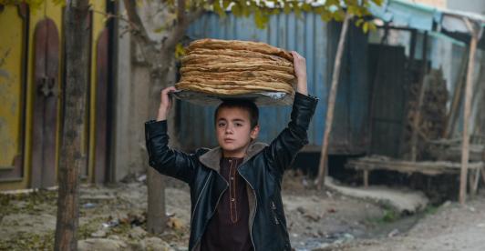 Un niño en Afganistán lleva panes por una calle del distrito de Fayzabad, en la provincia de Badakhshan.