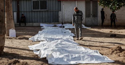 Un hombre observa las bolsas con restos humanos tras la exhumación de las tumbas por parte de la defensa civil en el interior del Hospital Bautista Árabe Al-Ahli para trasladar los restos a los cementerios oficiales de la ciudad de Gaza. 