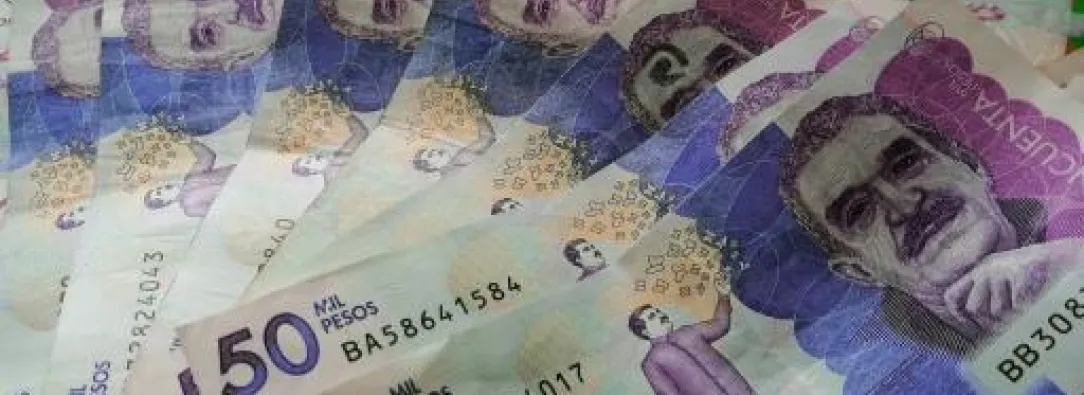 Foto representando inversión con billetes de 50.000 pesos colombianos.