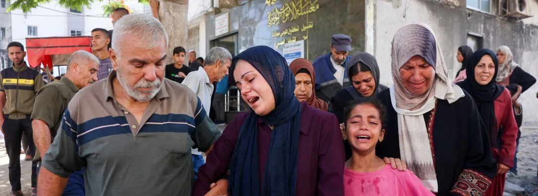 Familia palestina llorando por la pérdida de un ser querido en Gaza, cuando iba a recoger ayuda humanitaria