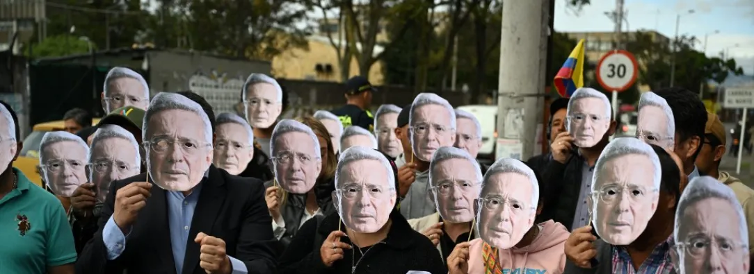 Personas con máscaras de Álvaro Uribe.