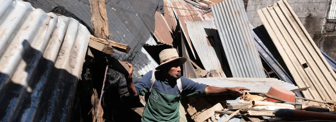 Mateo Rancho, de 70 años, permanece en el interior de su casa junto a la pared derrumbada de una tienda tras una serie de terremotos que sacudieron la zona en Santa María de Jesús, Guatemala.