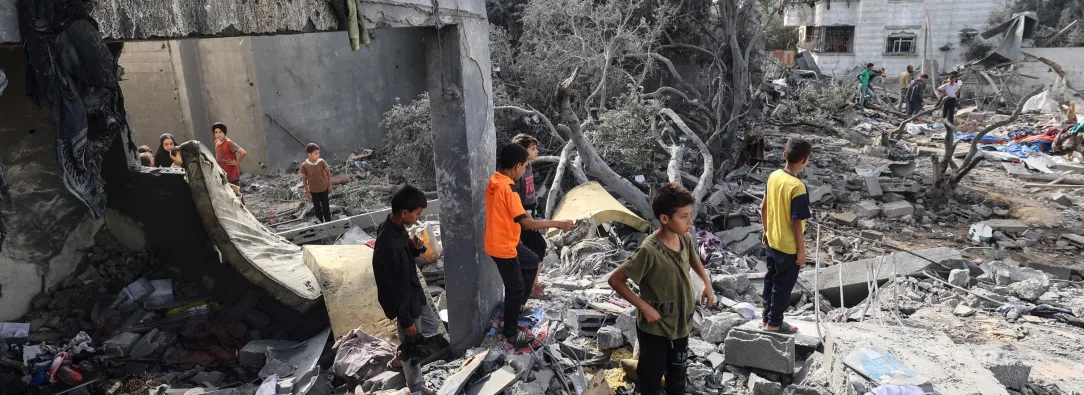 Niños palestinos revisan los escombros de una casa residencial en Deir el-Balah, en el centro de la Franja de Gaza.