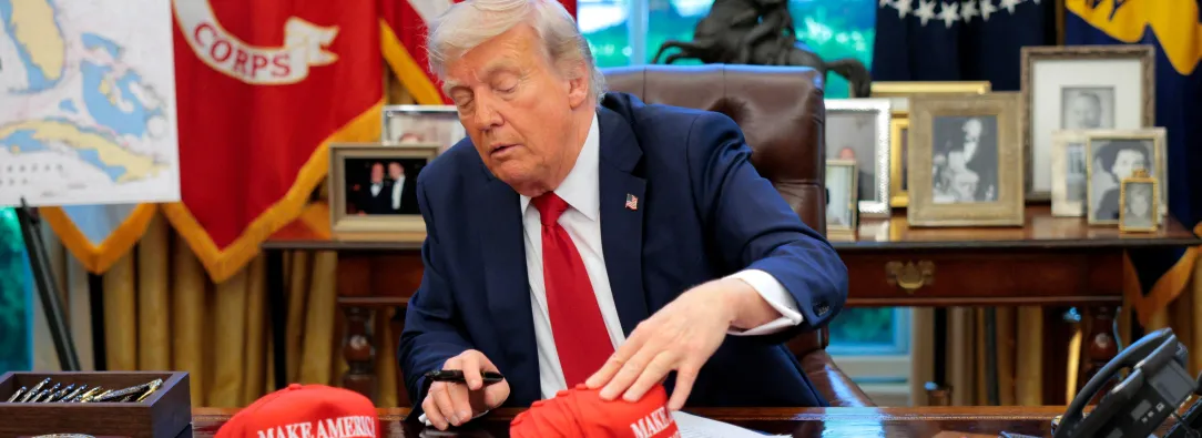 El presidente Donald Trump acomoda sus gorritas con el lema "Make America Great Again"