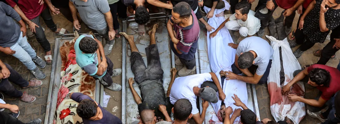 La gente rodea los cadáveres de palestinos, algunos muertos en los ataques israelíes de madrugada y otros asesinados el día anterior mientras buscaban ayuda humanitaria cerca de Zikim, al oeste de Beit Lahia, en el patio del hospital al-Shifa de la ciudad de Gaza.