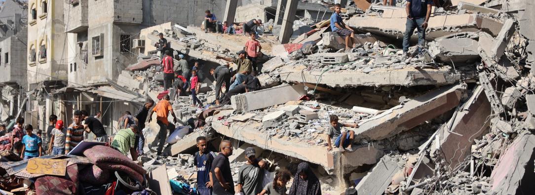 Palestinos inspeccionan un edificio destruido tras el bombardeo nocturno del ejército israelí sobre el campo de refugiados palestinos de Al-Shati, al oeste de la ciudad de Gaza.