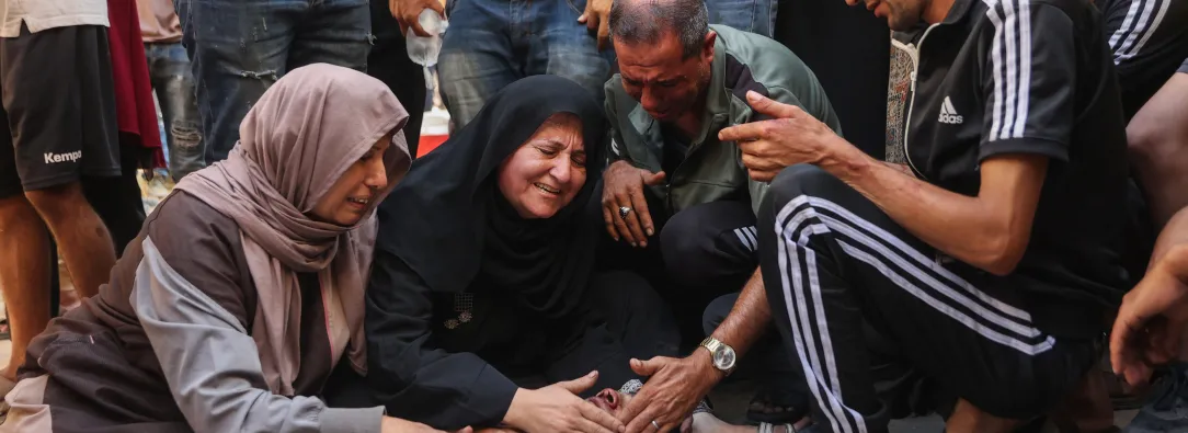 Los palestinos lloran junto al cadáver de un familiar asesinado en los ataques israelíes contra la ciudad de Gaza al amanecer, en el hospital Al-Shifa. 