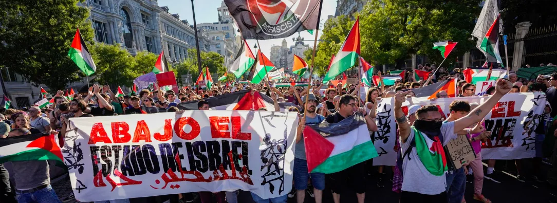 Manifestantes pro palestinos enarbolan banderas y pancartas palestinas tras invadir la calle y obligar a los organizadores de la carrera a suspender la 21.ª y última etapa de la Vuelta a España 2025, una carrera de 101 km entre Alalpardo y Madrid, en Madrid.