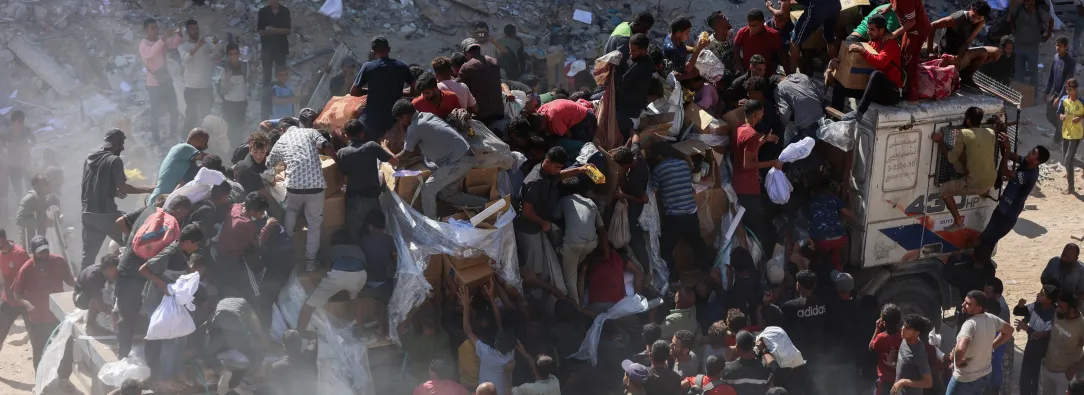 Los palestinos se apresuran a recibir paquetes de alimentos después de que los camiones de ayuda entraran por el paso fronterizo de Karem Abu Salem, en Jan Yunis, al sur de la Franja de Gaza.
