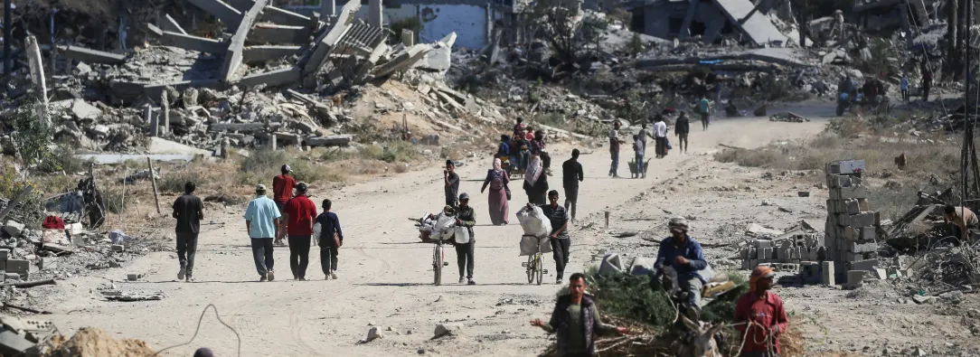 Vertriebene Palästinenser gehen an zerstörten Gebäuden vorbei, als sie in ihre Häuser im Gebiet al-Zahra nördlich des Flüchtlingslagers Nuseirat im zentralen Gazastreifen zurückkehren.