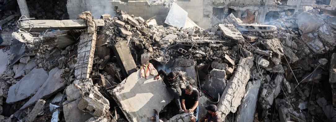 Palestinos intentan recuperar un cadáver de entre los escombros de una casa destruida en un ataque israelí durante la noche, en la ciudad de Gaza.