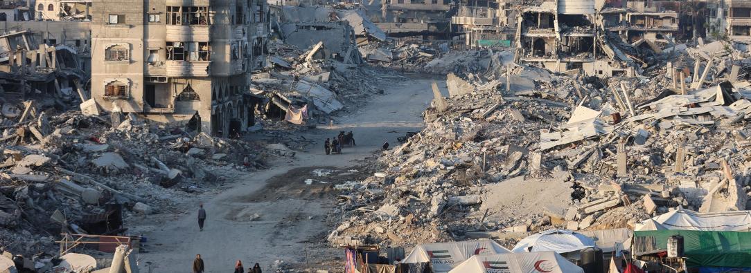 Palestinos caminan entre los escombros de edificios destruidos en el barrio de Sheikh Radwan, en la ciudad de Gaza.