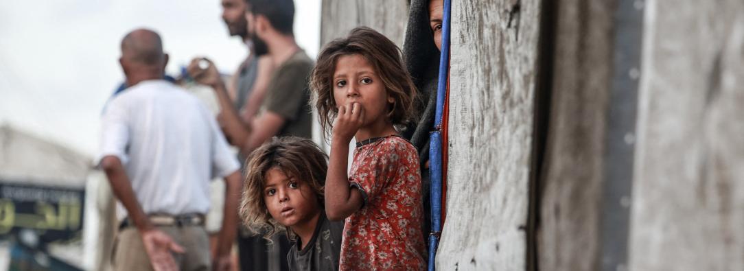 Niñas palestinas desplazadas junto a la entrada de una tienda utilizada como refugio temporal en Deir el-Balah, en la Franja de Gaza central.