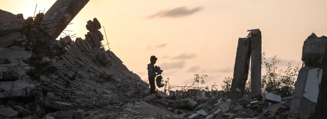 Un joven palestino recoge un trozo de escombro en Nuseirat, durante el genocidio palestino perpetrado por Israel, blanqueado por influencers colombianos