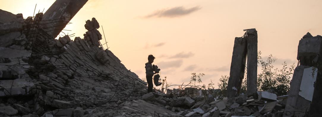 Un joven palestino recoge un trozo de escombro en Nuseirat, durante el genocidio palestino perpetrado por Israel, blanqueado por influencers colombianos