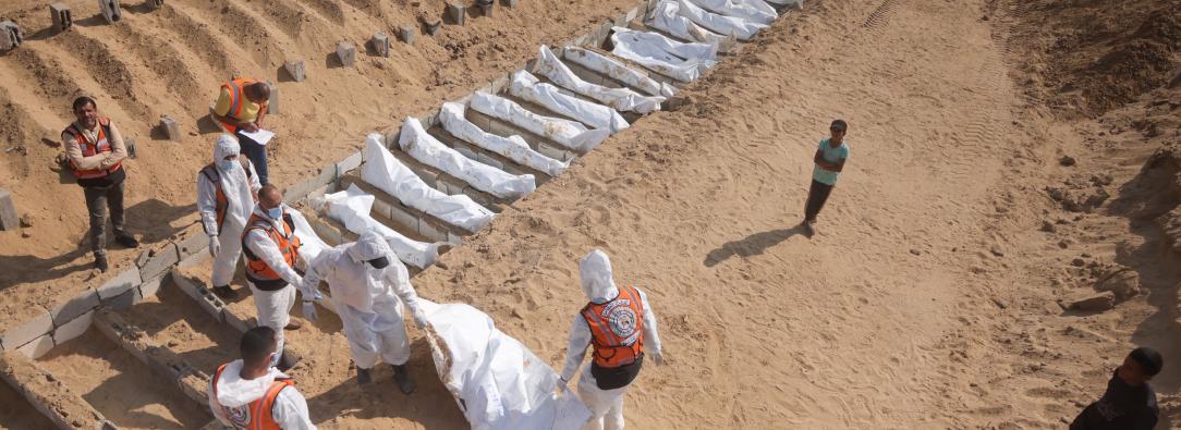 Trabajadores sanitarios y civiles realizan un entierro masivo de palestinos en un cementerio de Jan Yunis, en el sur de la Franja de Gaza.