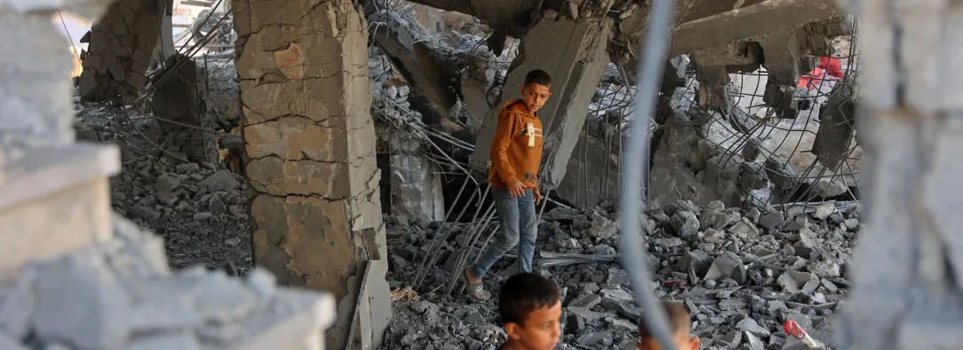 Niños palestinos caminan entre los escombros de un edificio dañado perteneciente al Ministerio de Dotaciones Religiosas, que albergaba a personas desplazadas en el barrio de Zeitoun, en la ciudad de Gaza. 