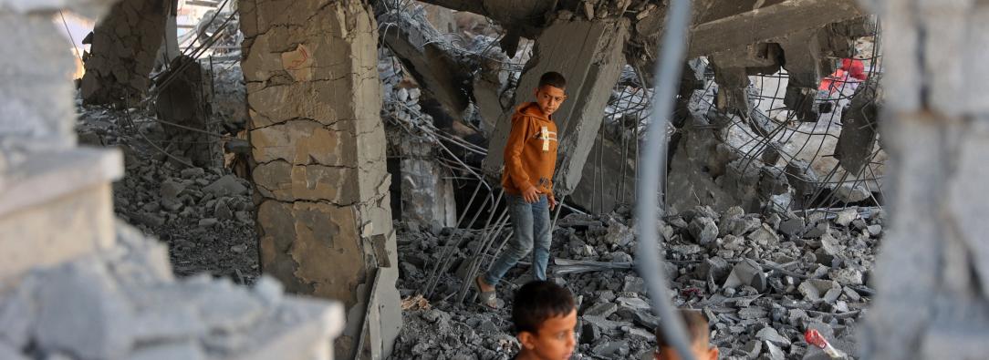 Niños palestinos caminan entre los escombros de un edificio dañado perteneciente al Ministerio de Dotaciones Religiosas, que albergaba a personas desplazadas en el barrio de Zeitoun, en la ciudad de Gaza. 