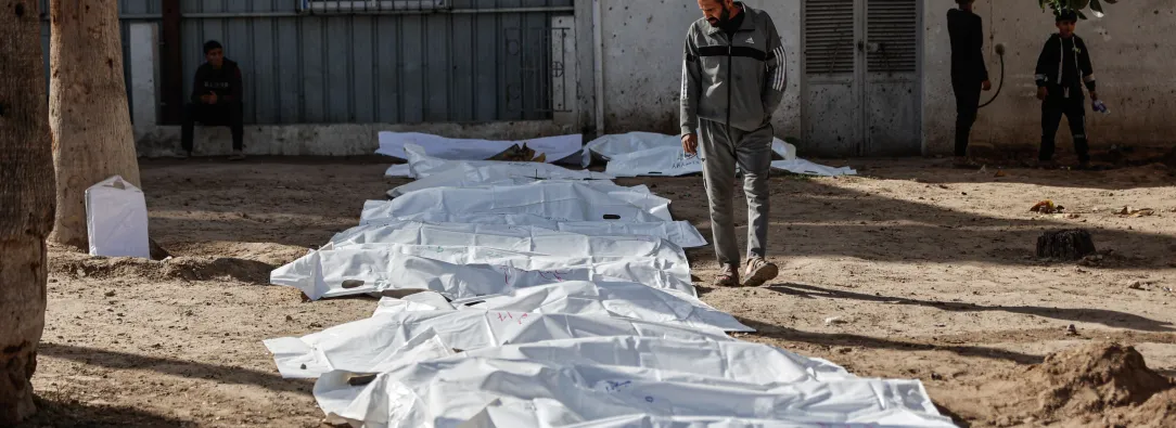 Un hombre observa las bolsas con restos humanos tras la exhumación de las tumbas por parte de la defensa civil en el interior del Hospital Bautista Árabe Al-Ahli para trasladar los restos a los cementerios oficiales de la ciudad de Gaza. 