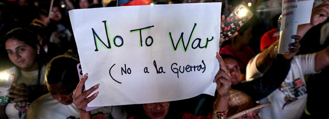 Un partidario del presidente venezolano Nicolás Maduro sostiene un cartel durante una manifestación en favor de la paz en Caracas y en contra del bloqueo militar por parte de EE. UU..