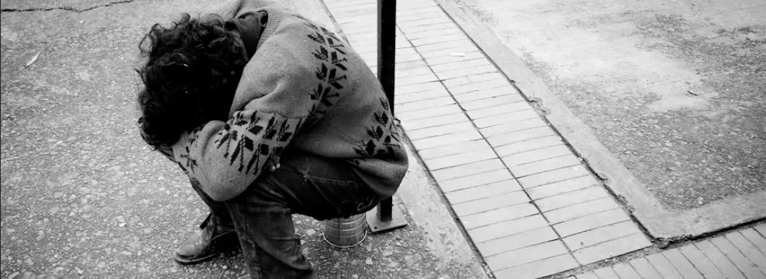 habitante de calle sentado y agachado