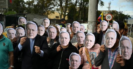 Personas con máscaras de Álvaro Uribe.