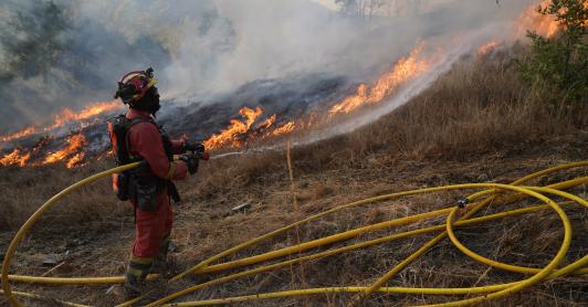 Un miembro de la Unidad Militar de Emergencias (UME) de España combate un incendio forestal en Garano, al noroeste de España.