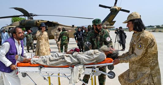 Voluntarios afganos y personal de seguridad talibán transportan a una víctima del terremoto evacuada por un helicóptero militar desde el distrito de Nurgal, en la provincia de Kunar, tras su llegada a Jalalabad para recibir asistencia médica.