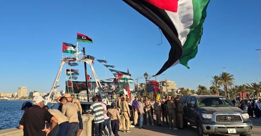 Personas posan para una foto frente al barco Omar al-Mukhtar, un barco libio que zarpó el 17 de septiembre para unirse a la Flotilla Global Sumud, en el puerto de Trípoli. 