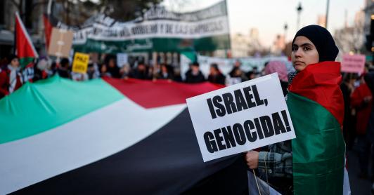 Una mujer sostiene un cartel con el lema «¡Israel, genocidio!» durante una manifestación en apoyo al pueblo palestino y para exigir el fin de la guerra en Gaza, celebrada en Madrid.