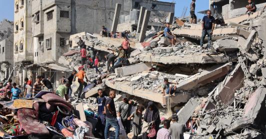 Palestinos inspeccionan un edificio destruido tras el bombardeo nocturno del ejército israelí sobre el campo de refugiados palestinos de Al-Shati, al oeste de la ciudad de Gaza.