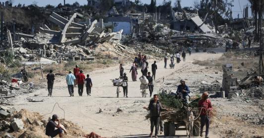 Vertriebene Palästinenser gehen an zerstörten Gebäuden vorbei, als sie in ihre Häuser im Gebiet al-Zahra nördlich des Flüchtlingslagers Nuseirat im zentralen Gazastreifen zurückkehren.