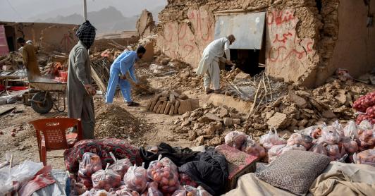 Los comerciantes de Afganistán buscan los restos de sus tiendas dañadas a lo largo de una carretera, tras un terremoto en Tang-e Tashkurgan, en el distrito de Khulm, provincia de Samangan.