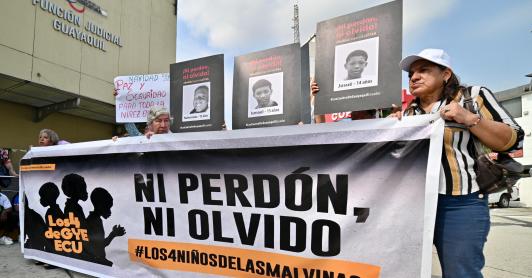 Familiares y miembros de organizaciones de derechos humanos sostienen fotografías y una pancarta con el lema «Ni perdón ni olvido» frente a un tribunal de Guayaquil, Ecuador, tras la condena de los 11 militares por desaparición forzada. 