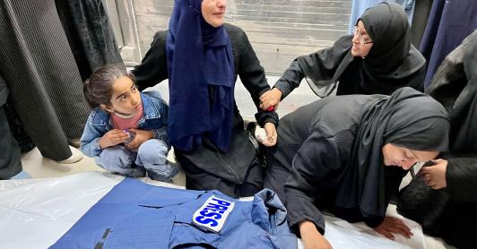 Familiares junto al cadáver del periodista Ahmed Mansur en el Complejo Médico Nasser, en Jan Yunis, al sur de la Franja de Gaza. Uno de los periodistas asesinados por Israel.