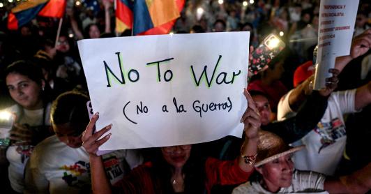 Un partidario del presidente venezolano Nicolás Maduro sostiene un cartel durante una manifestación en favor de la paz en Caracas y en contra del bloqueo militar por parte de EE. UU..