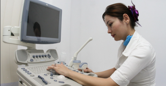persona del sector salud operando una máquina de ecografías